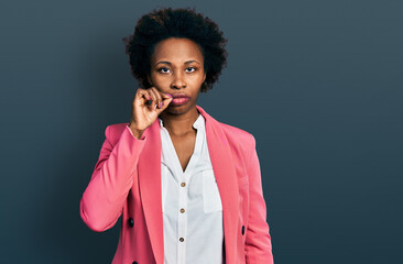 Poster - African american woman with afro hair wearing business jacket mouth and lips shut as zip with fingers. secret and silent, taboo talking