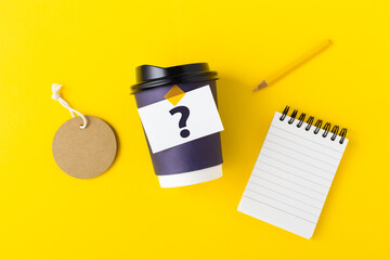 Wall Mural - takeaway coffee cup with tag and notebook, branding mockup on yellow background