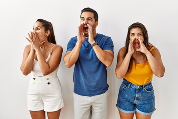 Sticker - Group of young hispanic people standing over isolated background shouting angry out loud with hands over mouth