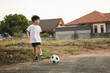 © bonnontawat - A 6 years old Asian boy kicking the ball as playing outdoor.