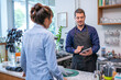 © todja - happy barista take order with tablet from customer in coffee shop.