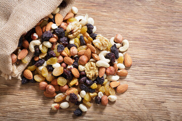 Wall Mural - mixed nuts with dried fruits on wooden background