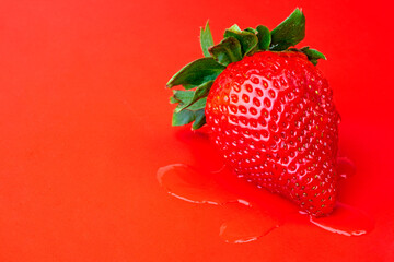 Wall Mural - a very tasty strawberry on a red