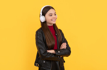 Wall Mural - cheerful teen girl listen music in headphones on yellow background, e-learning