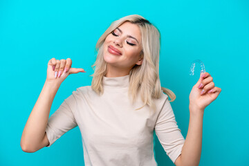 Young Russian woman holding invisaging isolated on blue background proud and self-satisfied