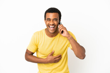 Wall Mural - African American handsome man using mobile phone over isolated white background smiling a lot