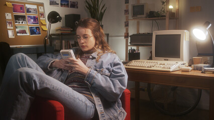 young girl playing with a 90s portable game console in her bedroom.