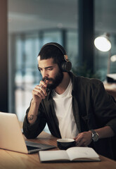 Aufkleber - Keep the music going and your business growing. Shot of a young businessman using a laptop and headphones during a late night at work.