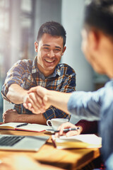 Poster - Making connections that count towards his success. Shot of two young designers shaking hands together in an office.