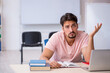 © Elnur - Young male student preparing for exams in the classroom