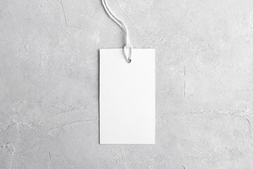 Rectangle white tag mockup with white cord, close up. Blank paper rectangular price tag mockup isolated on grey background with copy space, Sale and Black Friday concept