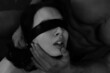 A man with a sporty figure blindfolds a woman with a black belt. BDSM, easy domination