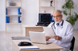 © Elnur - Old male doctor working in the clinic