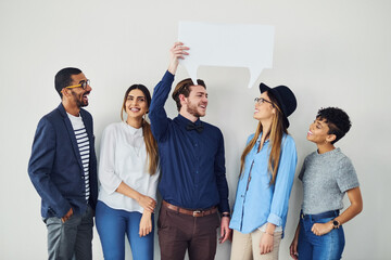 Poster - Saying it together. Shot of a diverse group of creative employees holding up a speech bubble inside.