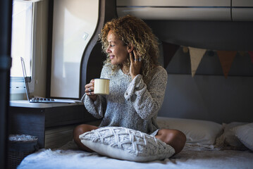 Wall Mural - Adult woman working on laptop computer enjoying freedom inside a camper van alternative van life home. Digital nomad and travel lifestyle people concept. Online digital job business and vacation van