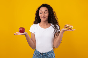 Wall Mural - Portrait of Smiling Lady Holding Apple And Burger