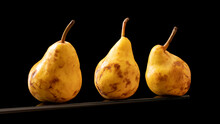 Three Yellow Pears On A Black Background