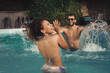 © New Africa - Happy couple having fun in outdoor swimming pool on sunny summer day