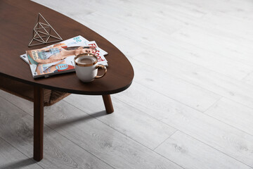 Sticker - Magazines and cup of coffee on wooden table indoors, space for text