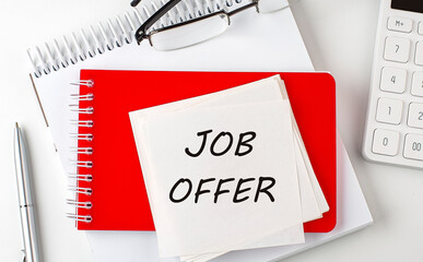Poster - JOB OFFER word on the sticker on notepad with pen and calculator