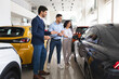© Prostock-studio - Cheerful middle eastern couple looking at black sports car