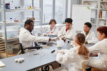 High Angle View At African American Teacher Demonstrating Science Experiments To Diverse Group Of Children In Chemistry Lab At School