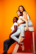 © iordani - diverse multi nation girls group, teenage friends company cheerful having fun, happy smiling, cute posing on yellow background, lifestyle people concept, african-american, asian and caucasian
