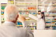 © Dusan Petkovic - A pharmacist getting drug that old man pointing at at pharmacy.