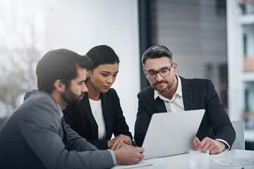 Poster - Theyre a team that gets things done. Shot of three businesspeople gathered around a laptop in the boardroom.