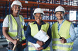 © Nicholas Felix/peopleimages.com - Shes the woman in charge. Shot of a group of contractors standing together in the warehouse.