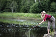 © alexkich - Girl by the river with a fishing rod
