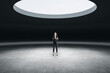 © Who is Danny - Thoughtful young european businesswoman standing in abstract space ship interior with spotlight from above. Presentation concept.