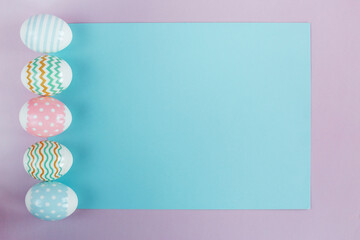 Easter eggs in pastel colors with a pattern on a pink background.