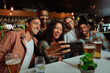 © Prins Productions - Group of young adult friends eating dinner at restaurant taking selfies