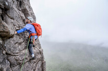 Man Wearing Helmet Climbing Rocky Mountain