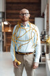 © Westend61 - Young businessman covered with cable standing in office