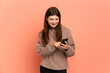 © luismolinero - Young Ukrainian girl isolated on pink background sending a message or email with the mobile