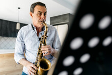 Saxophonist Practicing Saxophone At Home