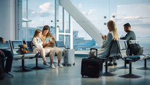 Airport Airplane Terminal: Cute Mother And Little Daughter Wait For Their Vacation Flight, Play E-Learning E-Educational Video Games On Digital Tablet. Young Family In Boarding Lounge Of Airline Hub