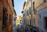 Fototapeta Uliczki - View on narrow and cozy street in the old town of Siena city in Italy. Concept of ancient architecture of the Tuscan region