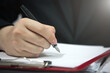 © Midnight Studio - businessman hand holding a pen to write on documents. concept of approval Signing of documents, checklists to verify business information, contracts, and MOU.