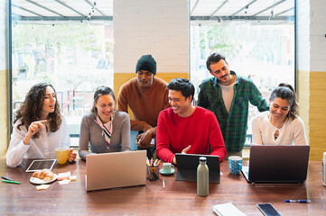 Front view group on young multiracial people with happy smiling faces working in a teamwork sitting at table.