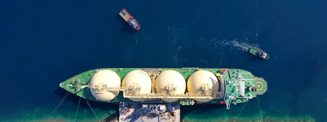 Sticker - Aerial drone ultra wide panoramic photo with copy space of LNG (Liquified Natural Gas) tanker anchored in small gas terminal island with tanks for storage