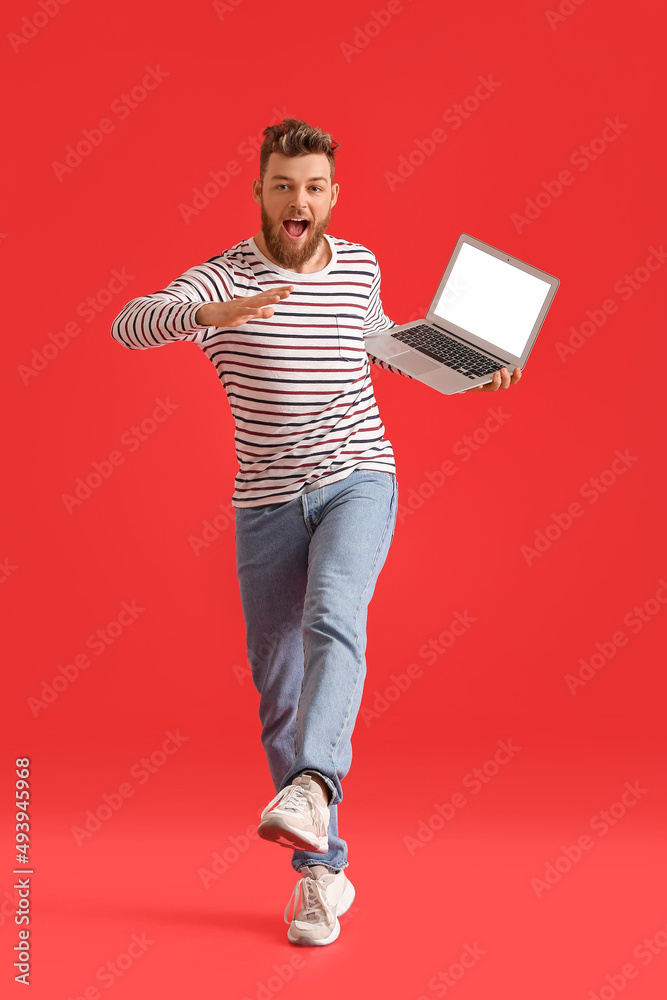 Cool dancing young man with laptop on color background