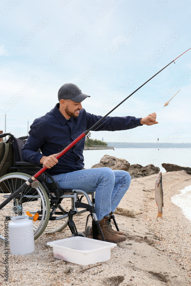 Man in wheelchair fishing on river