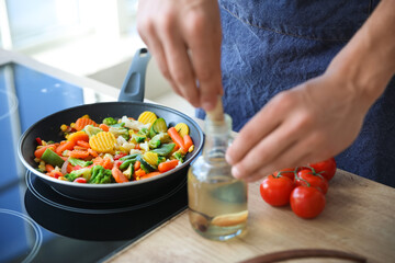 Frying pan with tasty vegetables on electric stove in kitchen, closeup