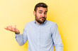 Young caucasian man isolated on yellow background doubting and shrugging shoulders in questioning gesture.
