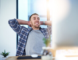 Fototapete - Taking a breather is great for a productivity booster. Shot of a young businessman relaxing at his work desk.