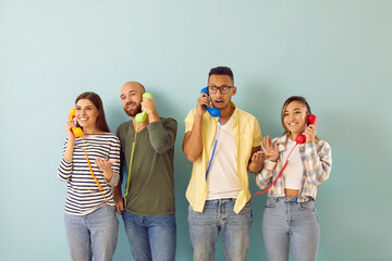 Wall Mural - Diverse people talk on landline phones with customer support or call center. Multiracial people clients speak on corded telephones, give opinion or feedback. Isolated on green studio background.