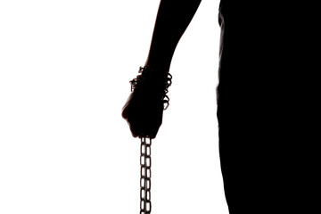 Dark silhouette of body and hand holding chain on the bright background